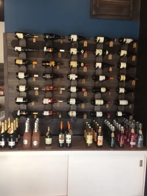 Présentation de bouteilles de vin alignées sur une étagère.