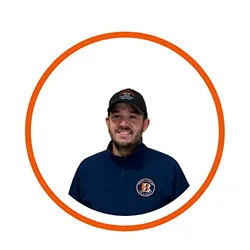 Portrait d'un homme souriant avec casquette et t-shirt bleu.