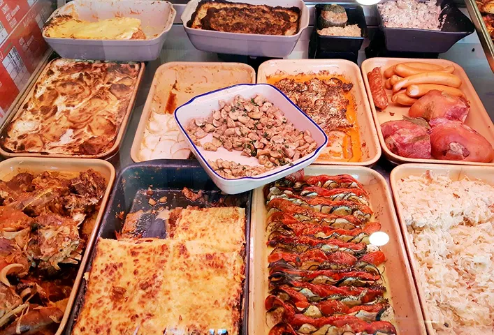 Plats cuisinés présentés dans des barquettes sur un comptoir.